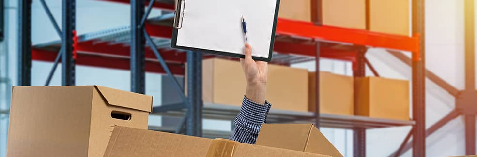 A hand with a notepad coming out of a messy pile of boxes in a warehouse environment